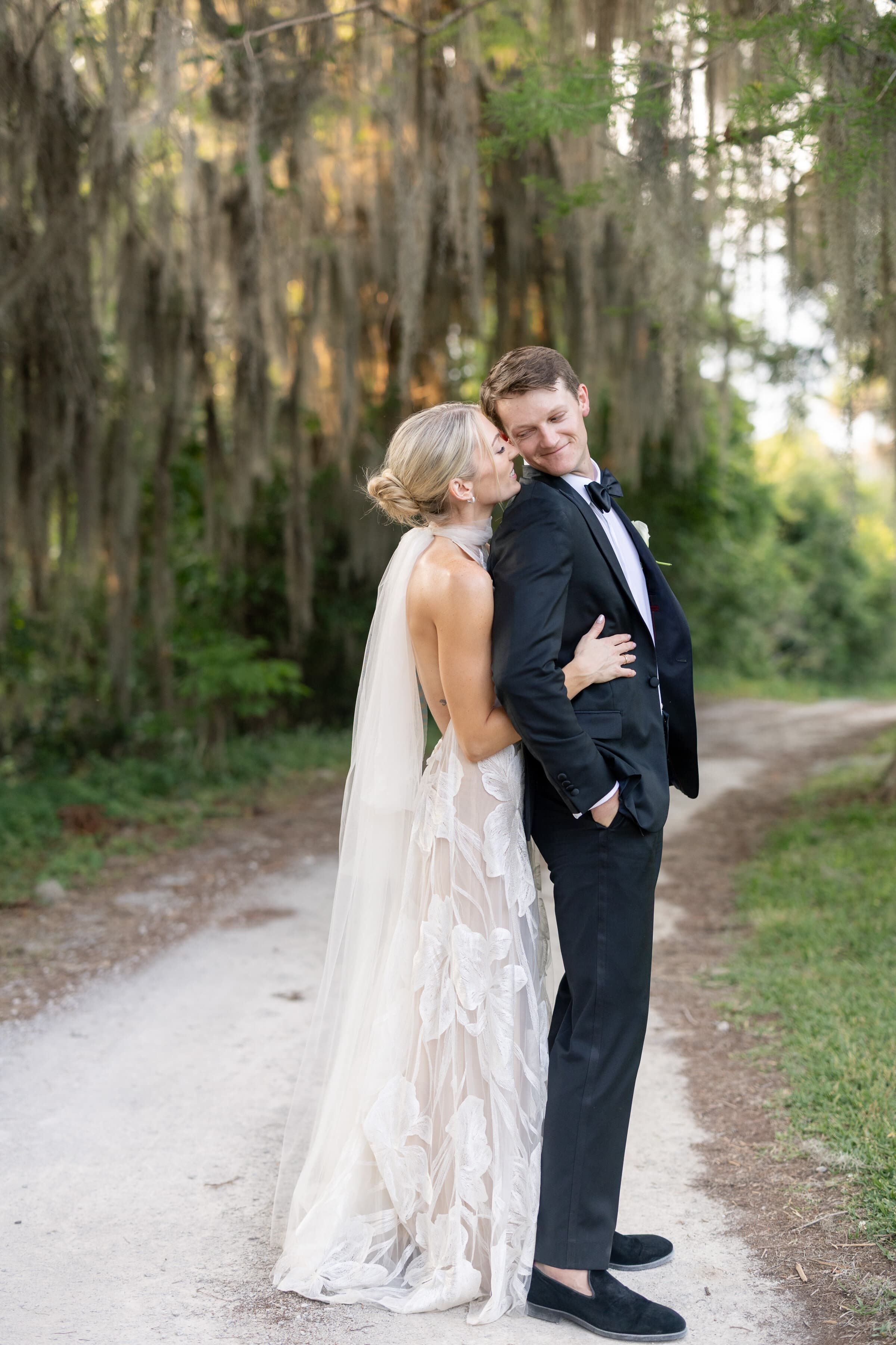 Newlyweds together on a wooded path after their wedding